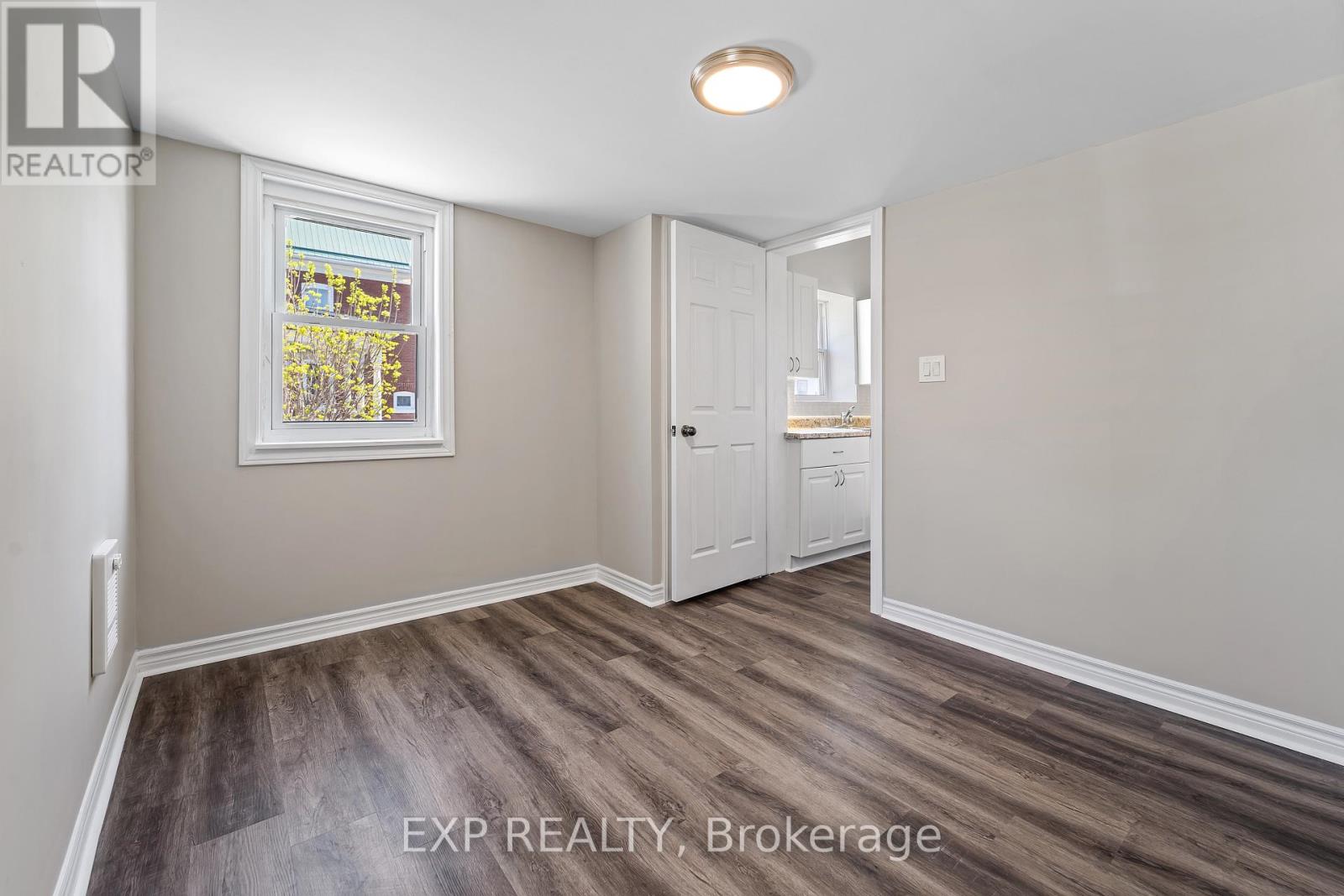 A room with a wooden floor and a white door.