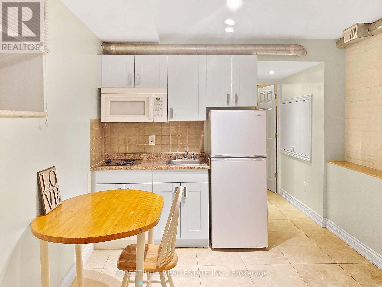 A kitchen with a table and chairs.