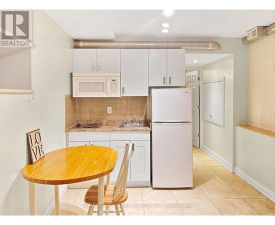 A kitchen with a table and chairs.