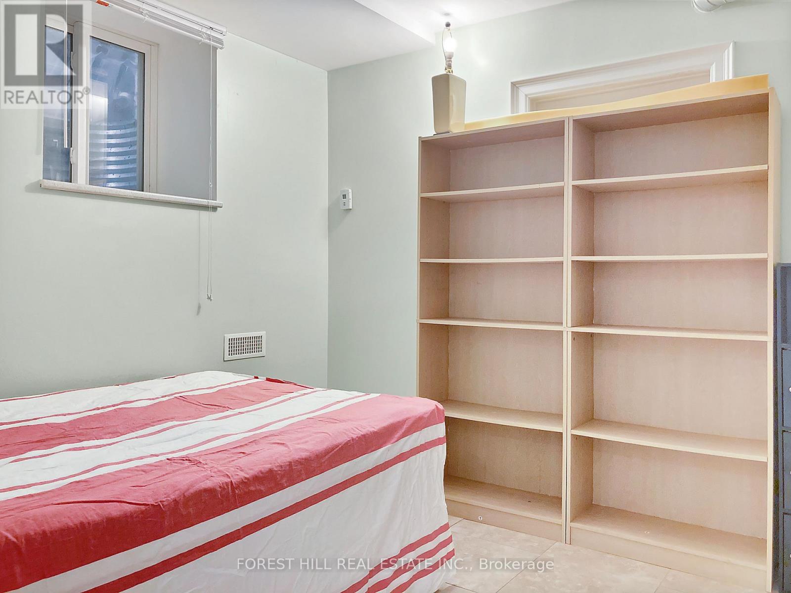 A bedroom with a large bed and a built-in bookshelf.