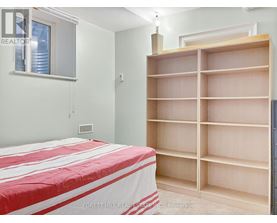 A bedroom with a large bed and a built-in bookshelf.