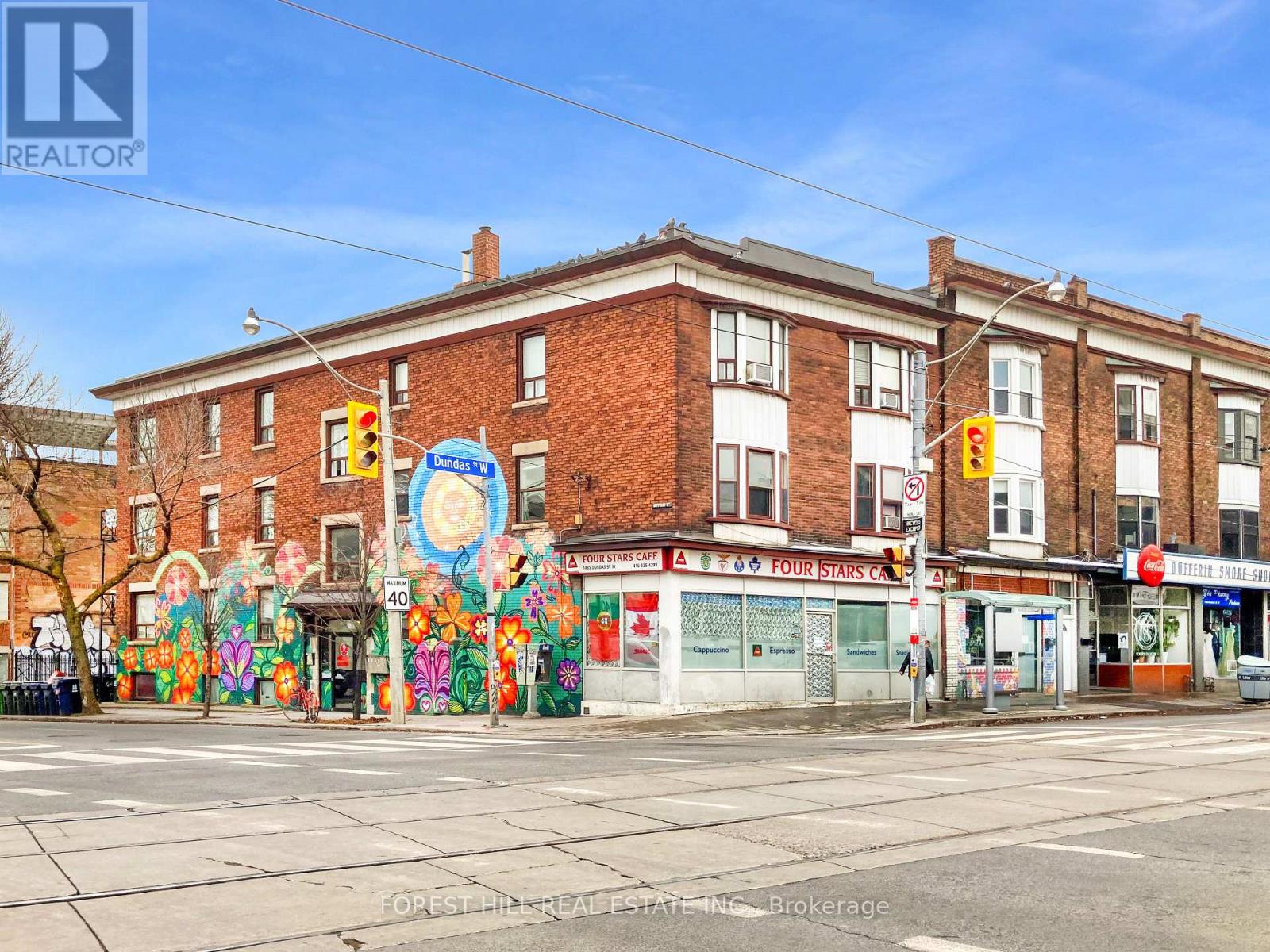 A street view of a building with a mural on the side.