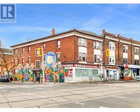 A street view of a building with a mural on the side.