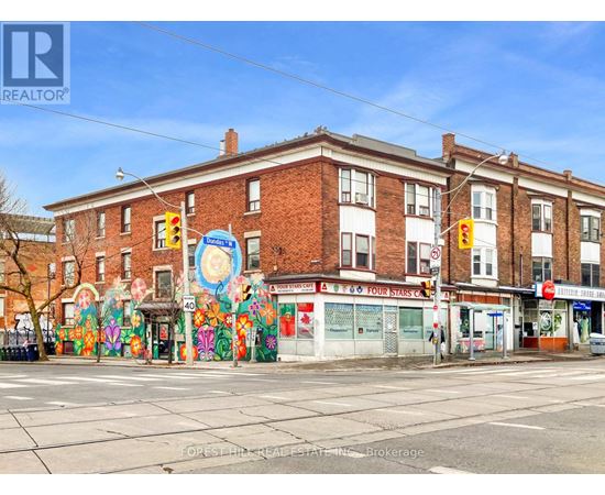 A street view of a building with a mural on the side.