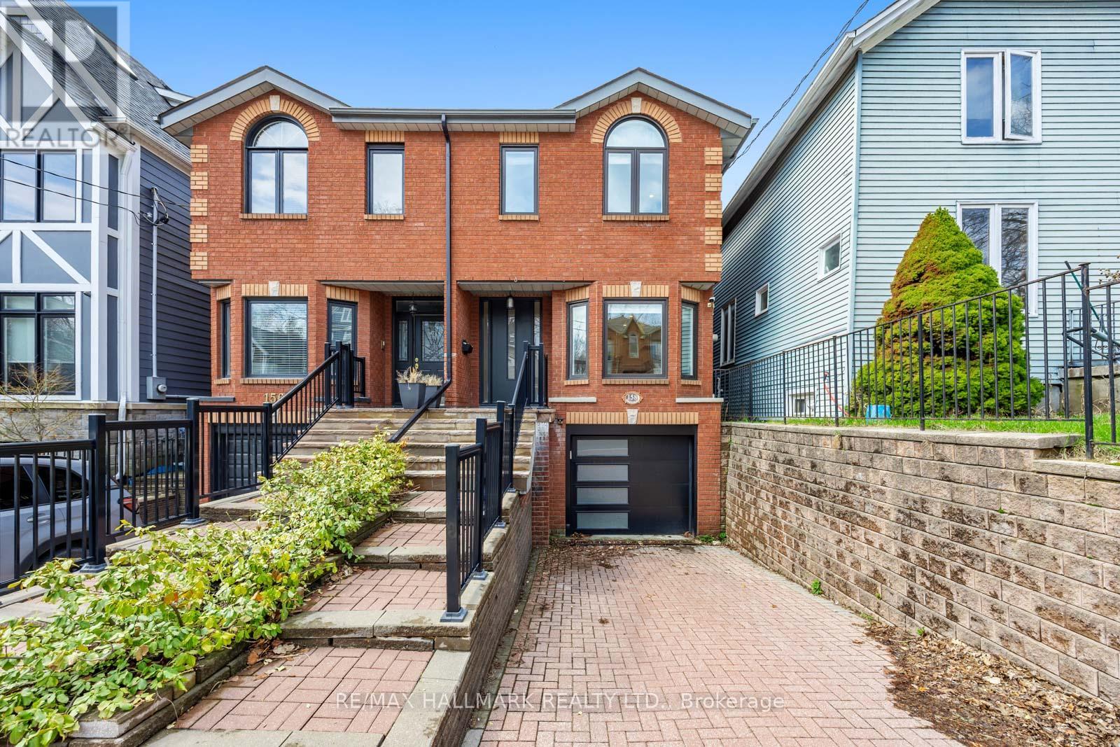 A red brick house with a black gate in front.