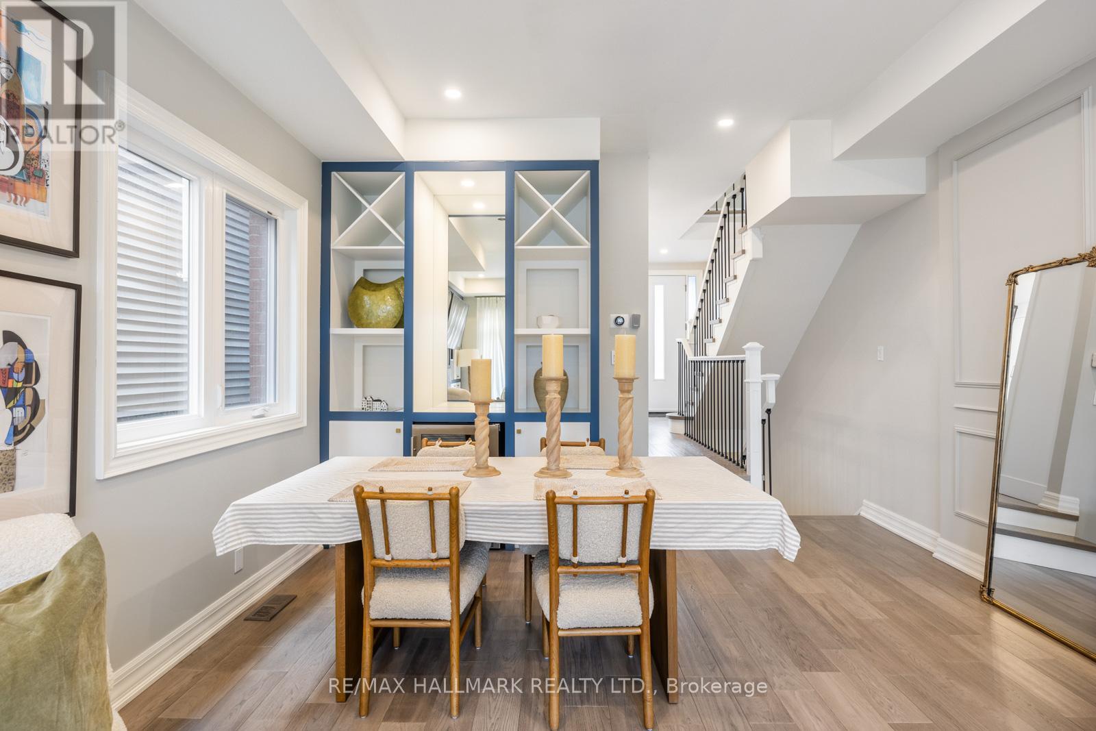 A dining room with a table set for two and a staircase in the background.