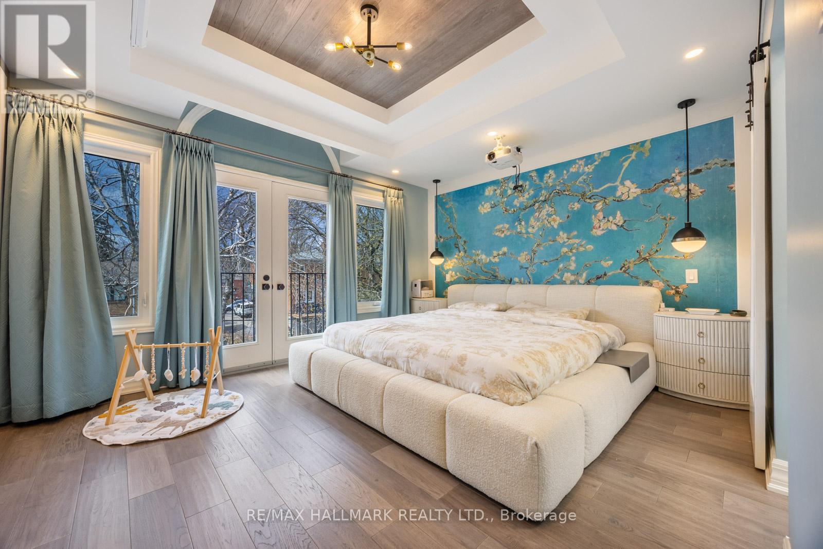 A bedroom with a large bed and a blue floral wallpaper.