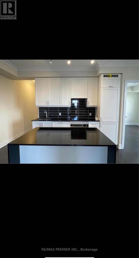 A kitchen with white cabinets and a black countertop.