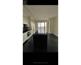 A black table in a white kitchen with a view of the balcony.