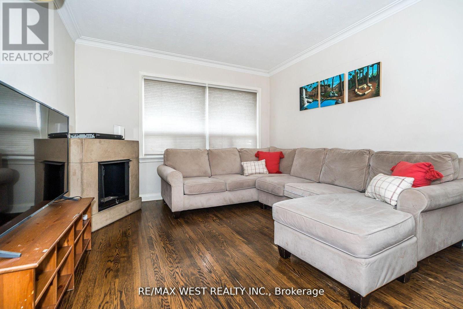 A living room with a grey couch and a wooden floor.