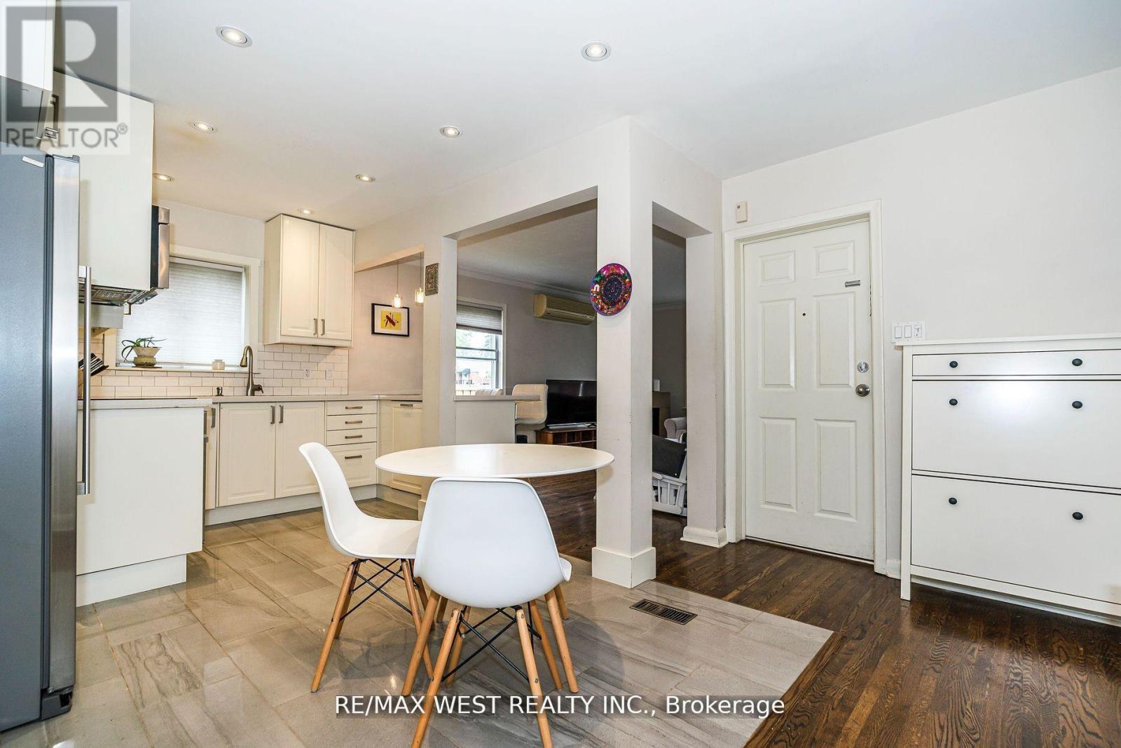A white kitchen with a table and chairs.
