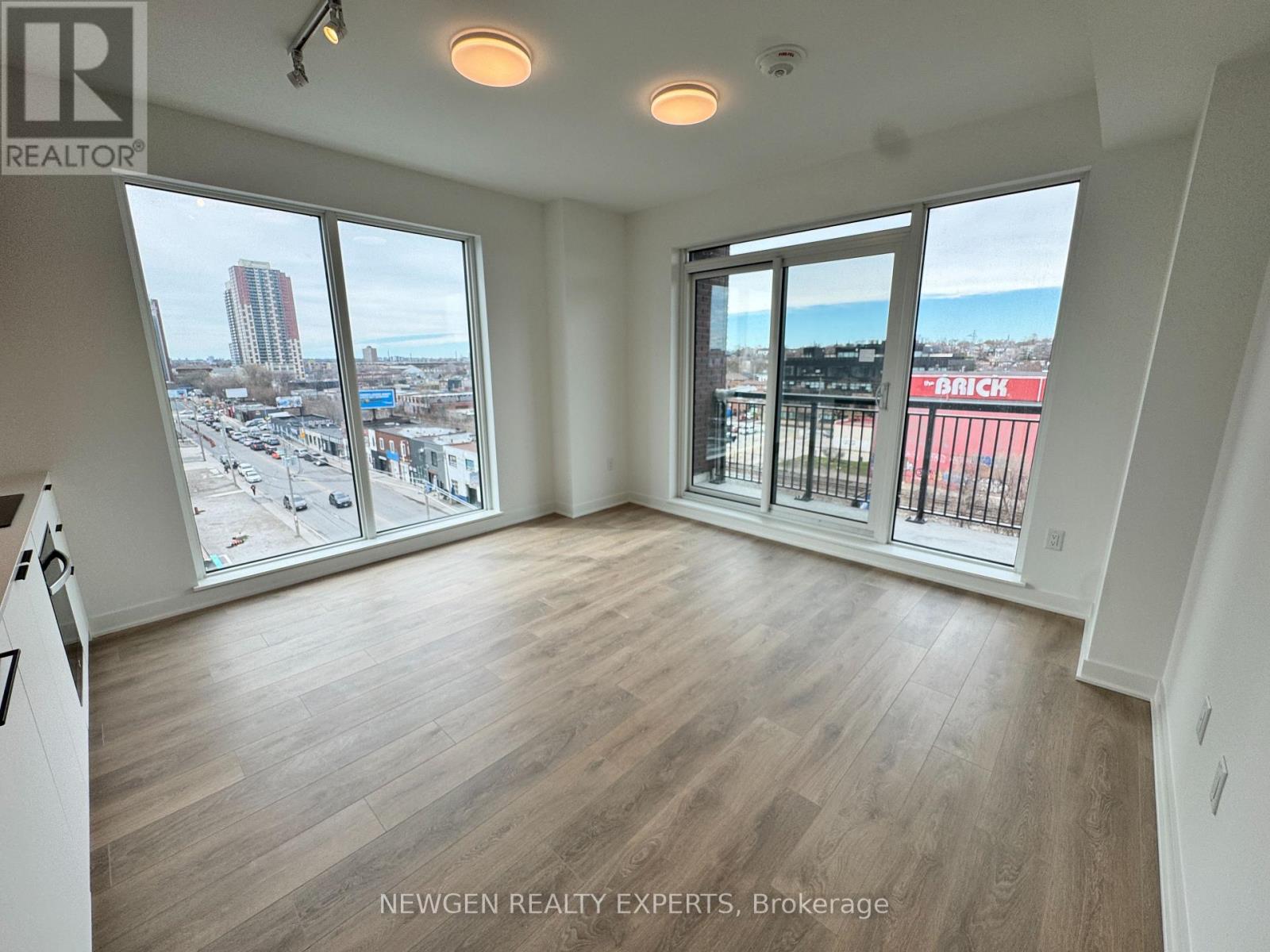 A spacious room with a view of the cityscape and beach through the windows.
