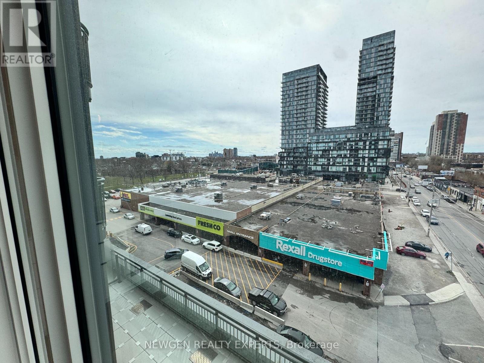 A view from a window looking out at a construction site with a large building under construction in the background.
