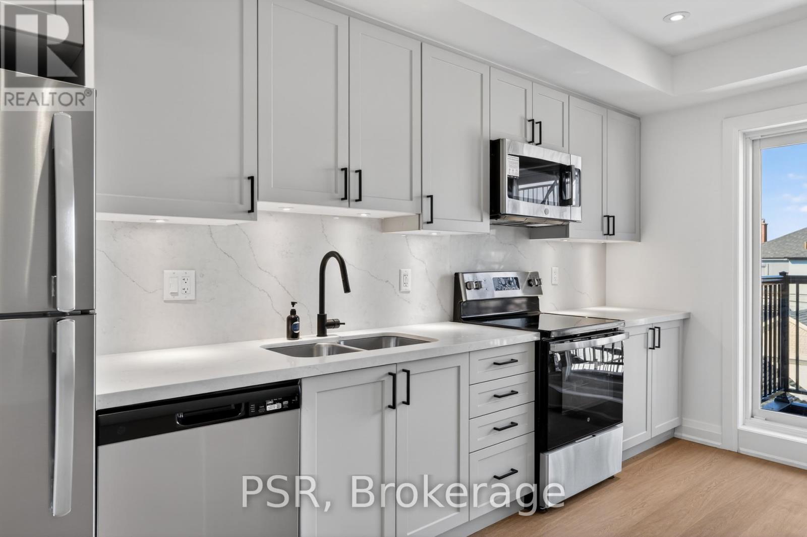 A modern kitchen with white cabinets and stainless steel appliances.