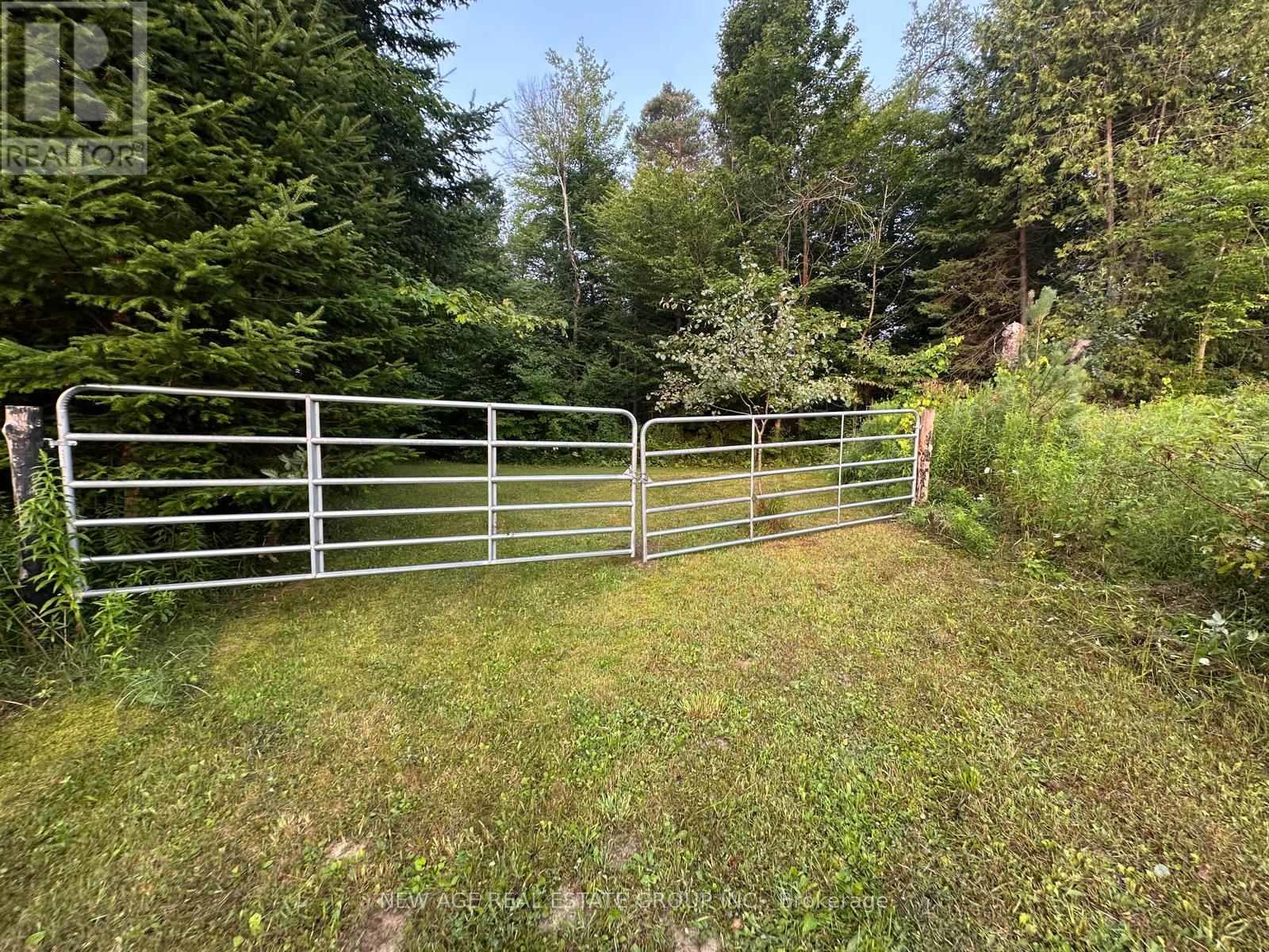 A metal gate blocks the entrance to a grassy area.