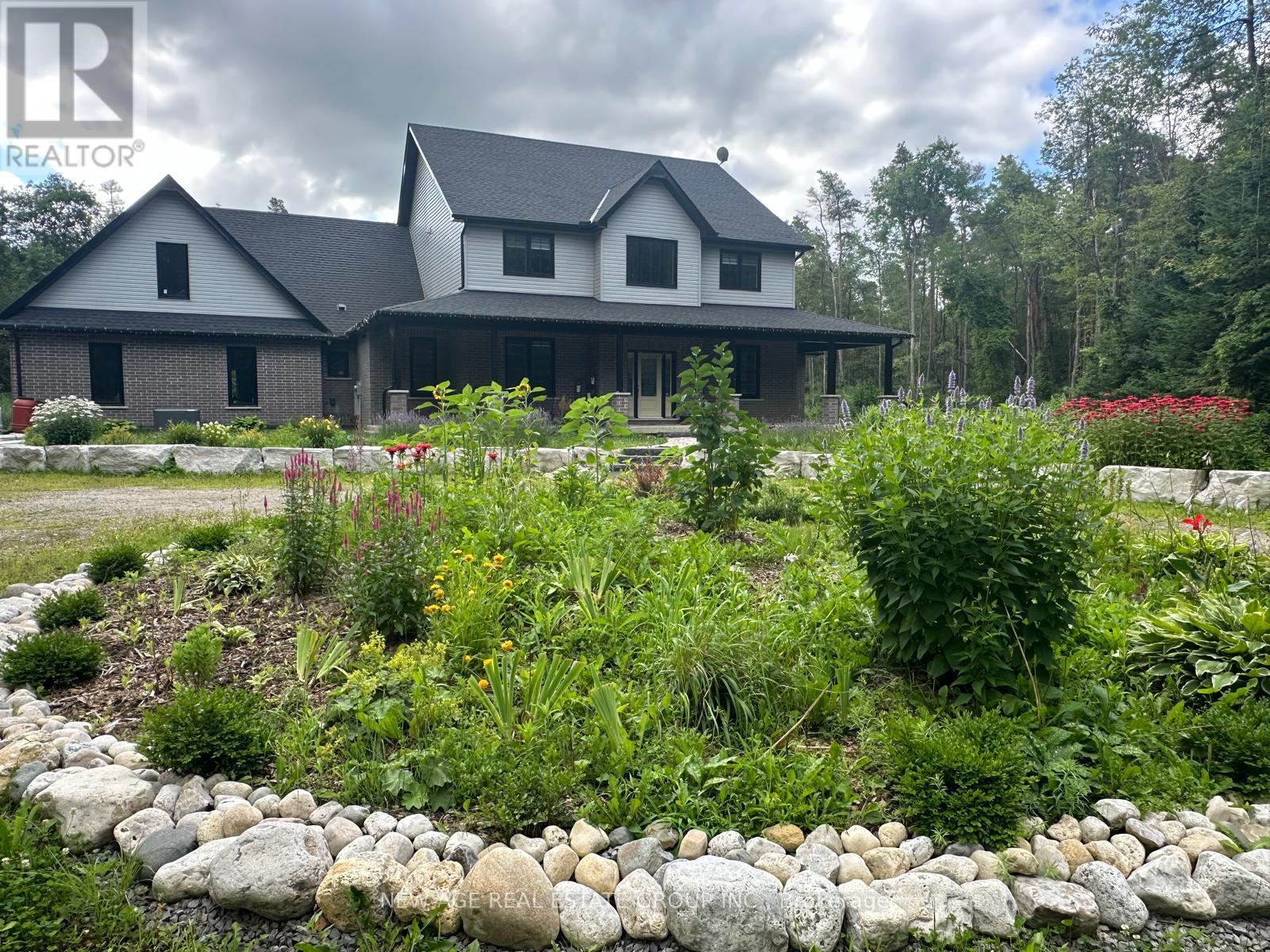 A house with a grey roof and a garden in front.