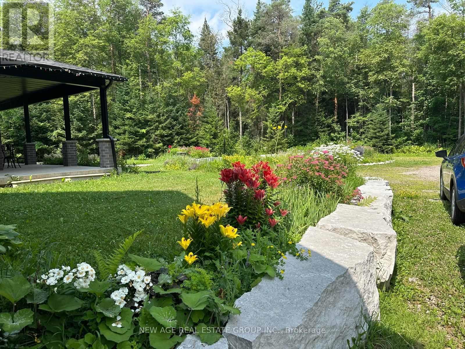 A garden with a stone pathway and a gazebo in the background.