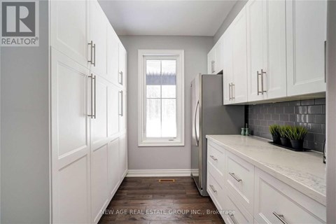A kitchen with white cabinets and a marble countertop.