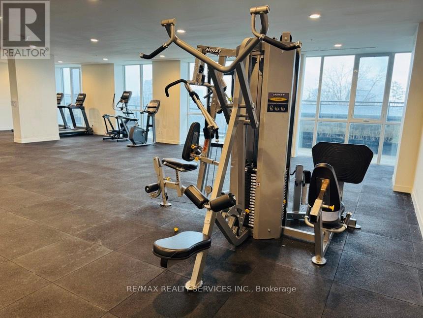 A gym with a row of treadmills and a row of stationary bikes.