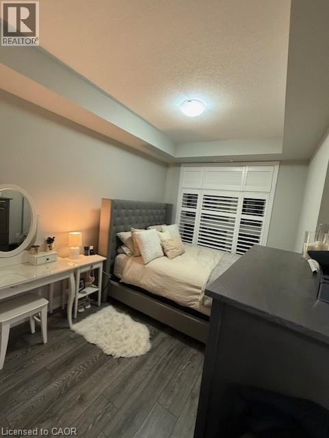 A bedroom with a bed, nightstand, and a vanity table.