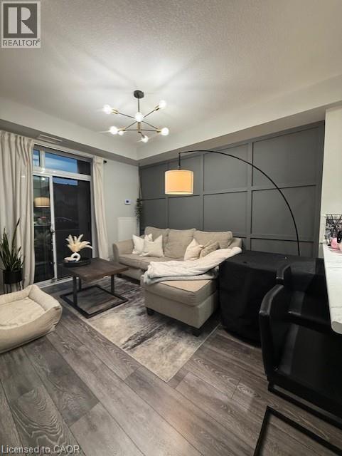 A modern living room with a grey sofa, a wooden coffee table, and a large window with curtains.