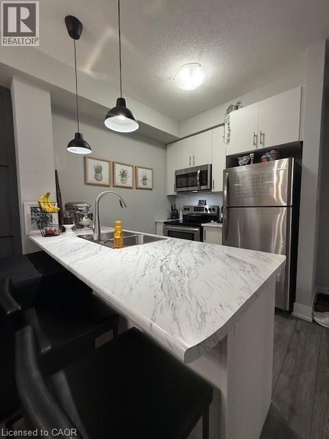 A kitchen with a marble countertop and stainless steel appliances.