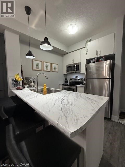 A kitchen with a marble countertop and stainless steel appliances.
