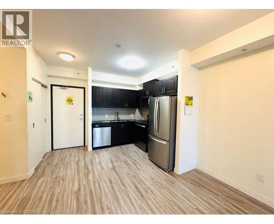 A kitchen with black cabinets and stainless steel appliances is shown.