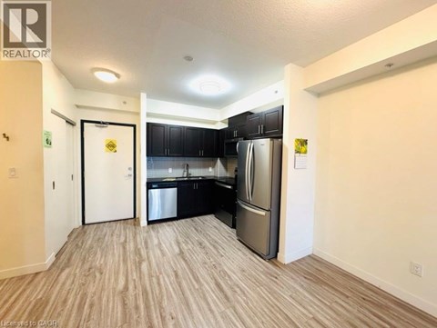 A kitchen with black cabinets and stainless steel appliances is shown.