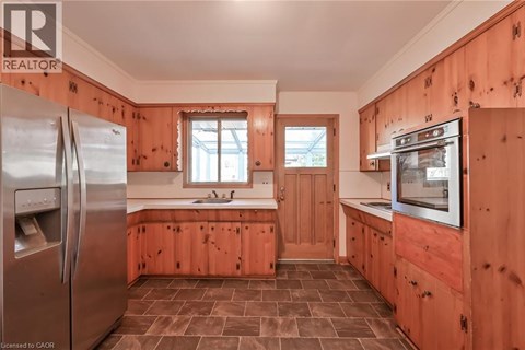 A kitchen with wooden cabinets and a refrigerator.