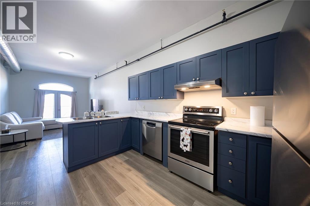 A kitchen with dark blue cabinets and stainless steel appliances.