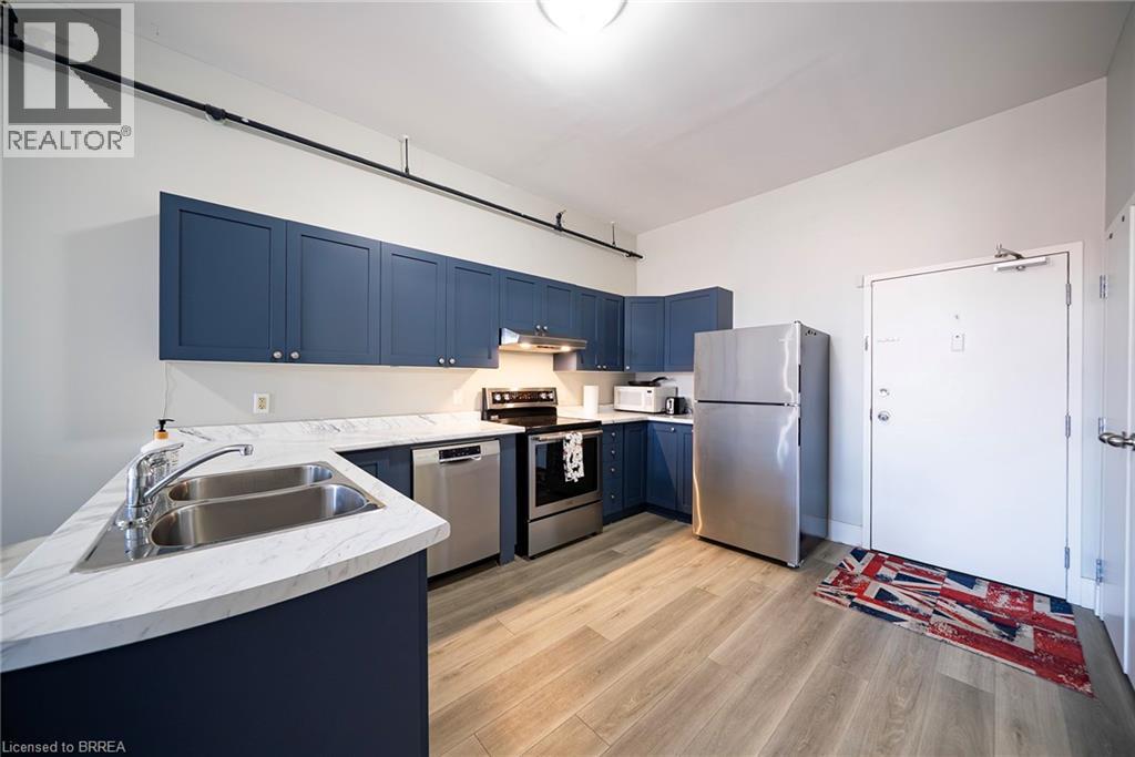 A kitchen with blue cabinets and stainless steel appliances.