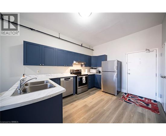 A kitchen with blue cabinets and stainless steel appliances.