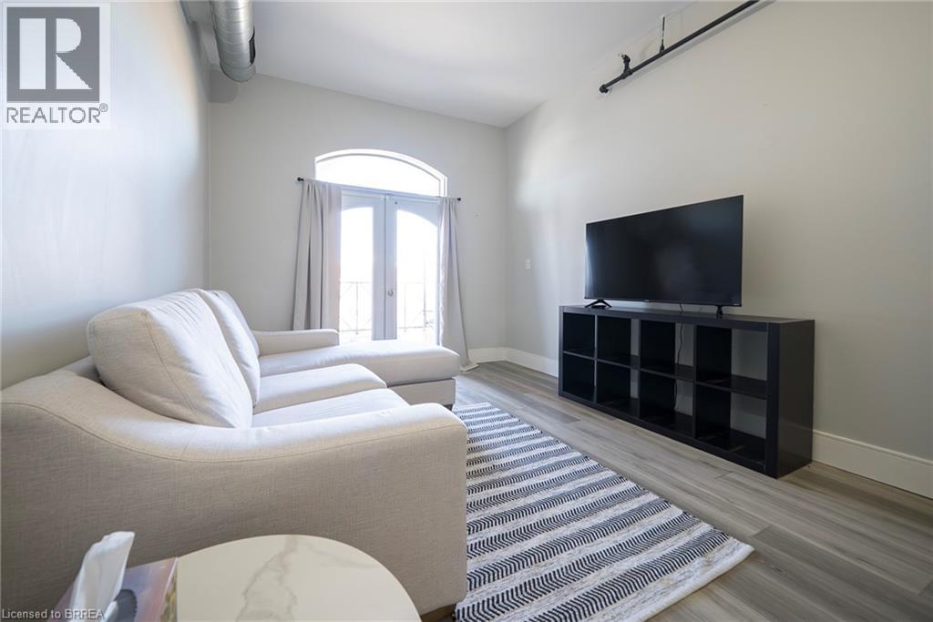 A living room with a white couch and a black television.