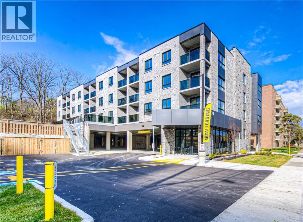 A modern apartment building with a parking lot in front.