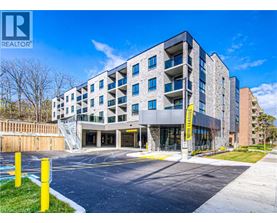 A modern apartment building with a parking lot in front.