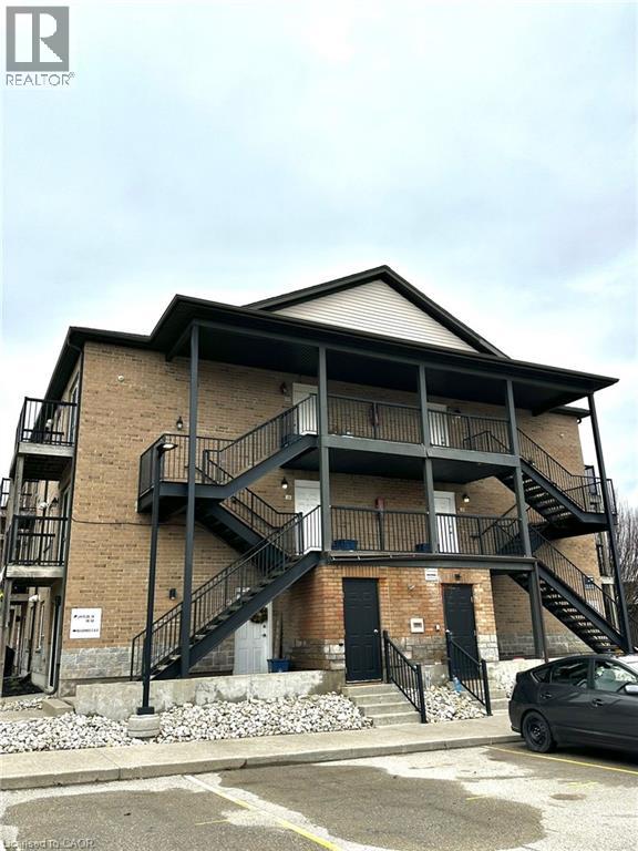 A multi-story building with a black car parked in front.