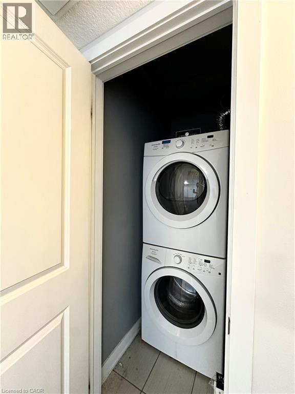A white washing machine is in a small space under a door.