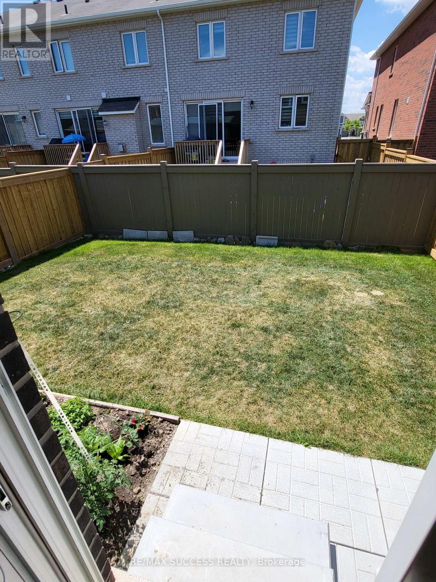 A backyard with a wooden fence and a small patch of grass.