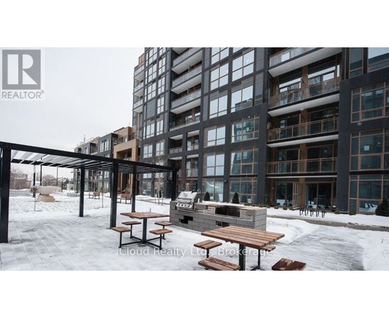 A snowy outdoor seating area in front of a modern building.