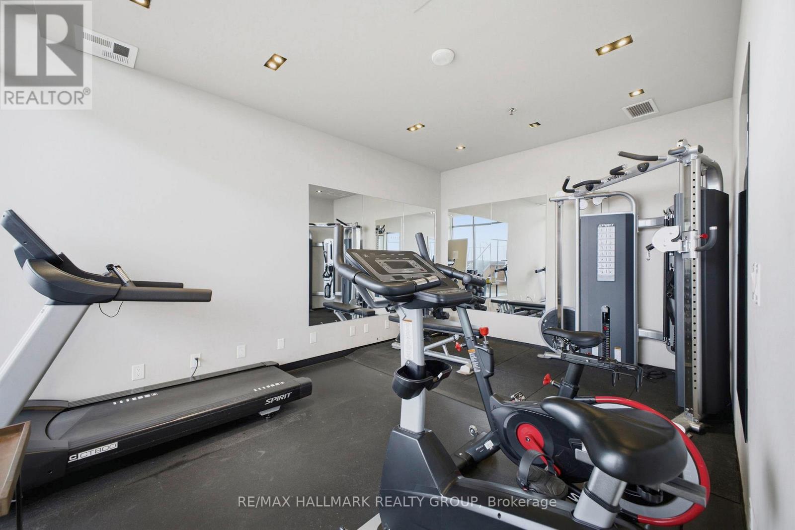 A spacious home gym with a treadmill, exercise bike, and weight machine.