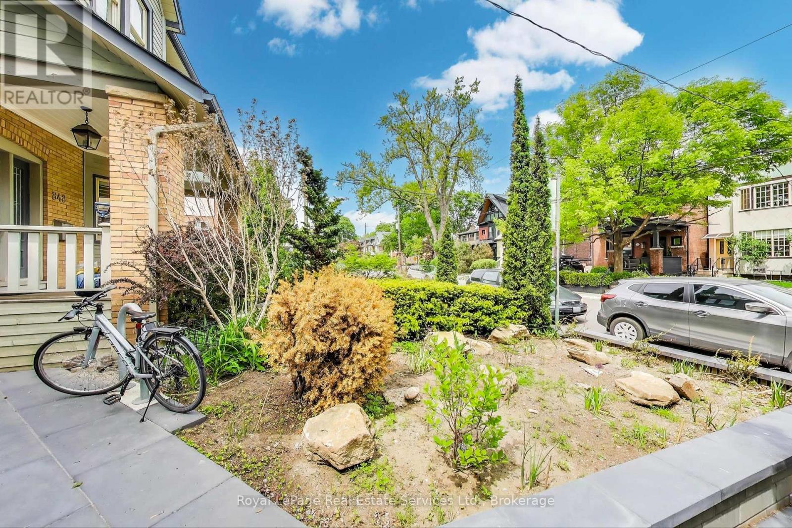 A bicycle is parked on a concrete slab in a yard.