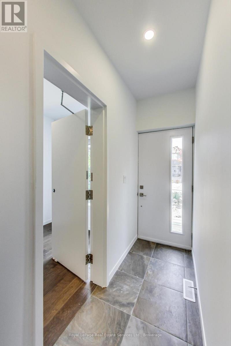 A hallway with a white door and a wooden floor.