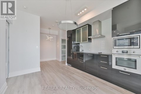 A modern kitchen with a white oven and wooden floors.