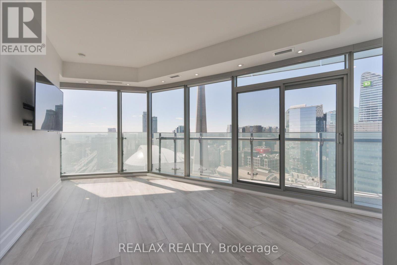 A spacious room with a view of the cityscape and the ocean.