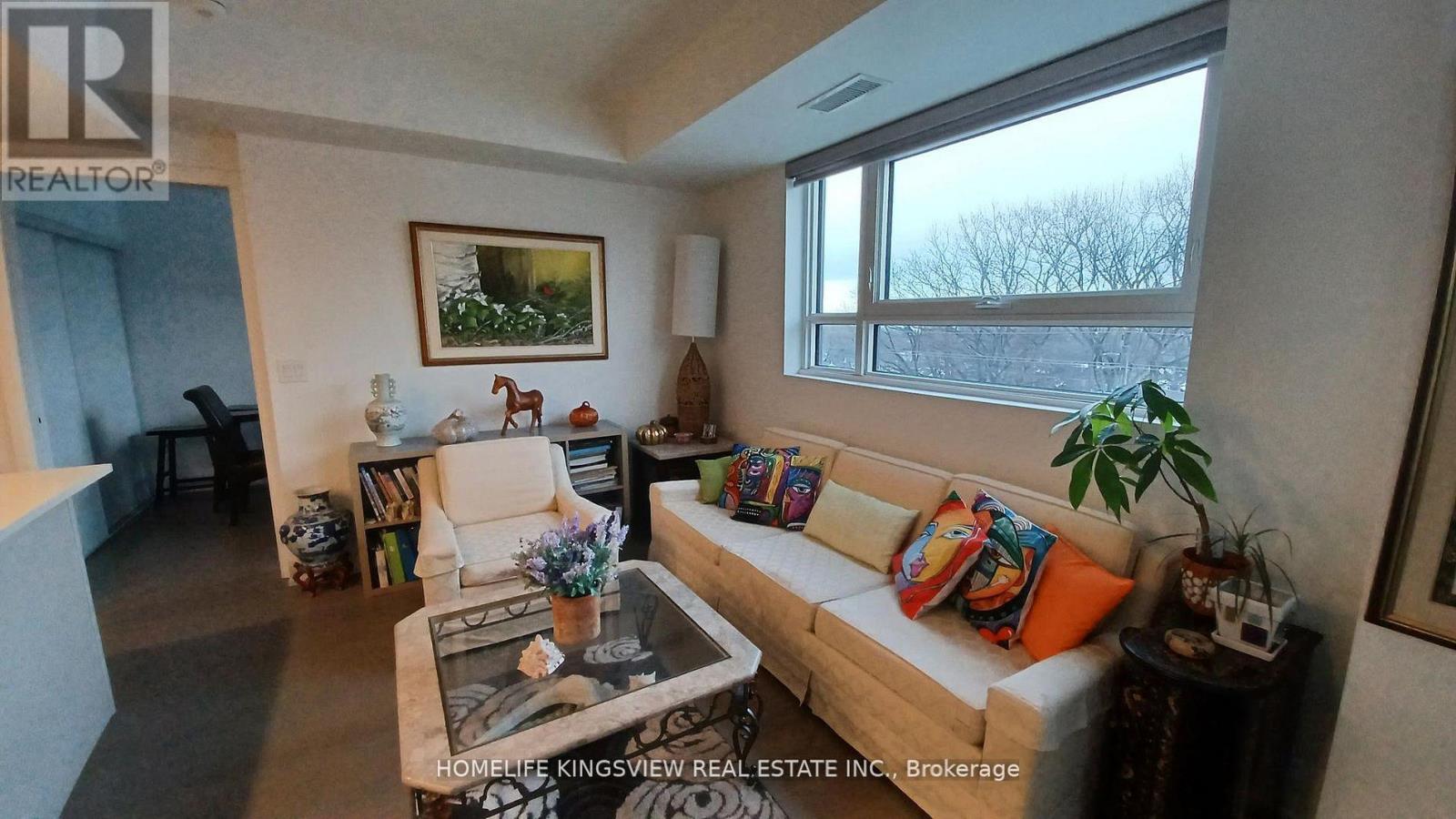 A living room with a couch, a coffee table, and a painting on the wall.