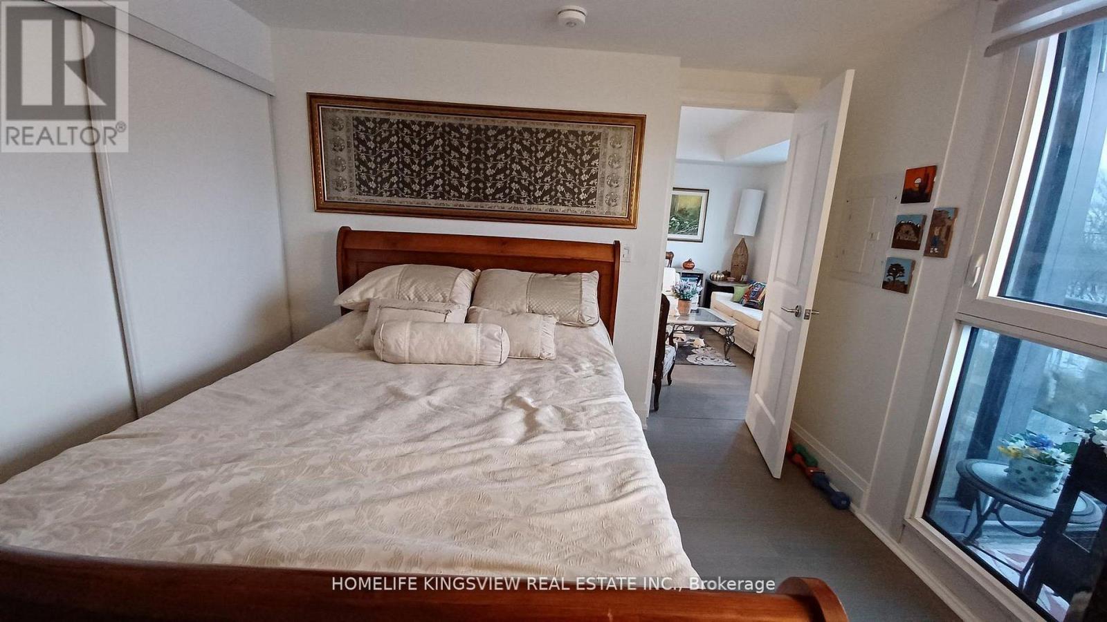 A bedroom with a bed, a chair, and a window.