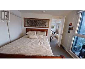 A bedroom with a bed, a chair, and a window.