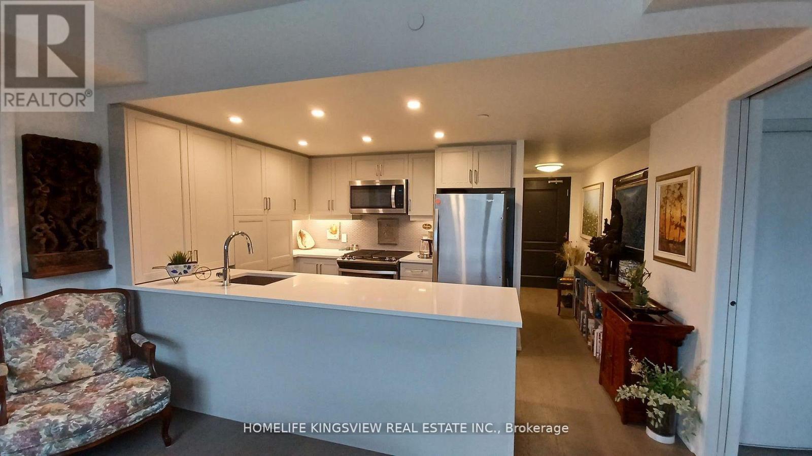 A kitchen with a sink, stove, and refrigerator.