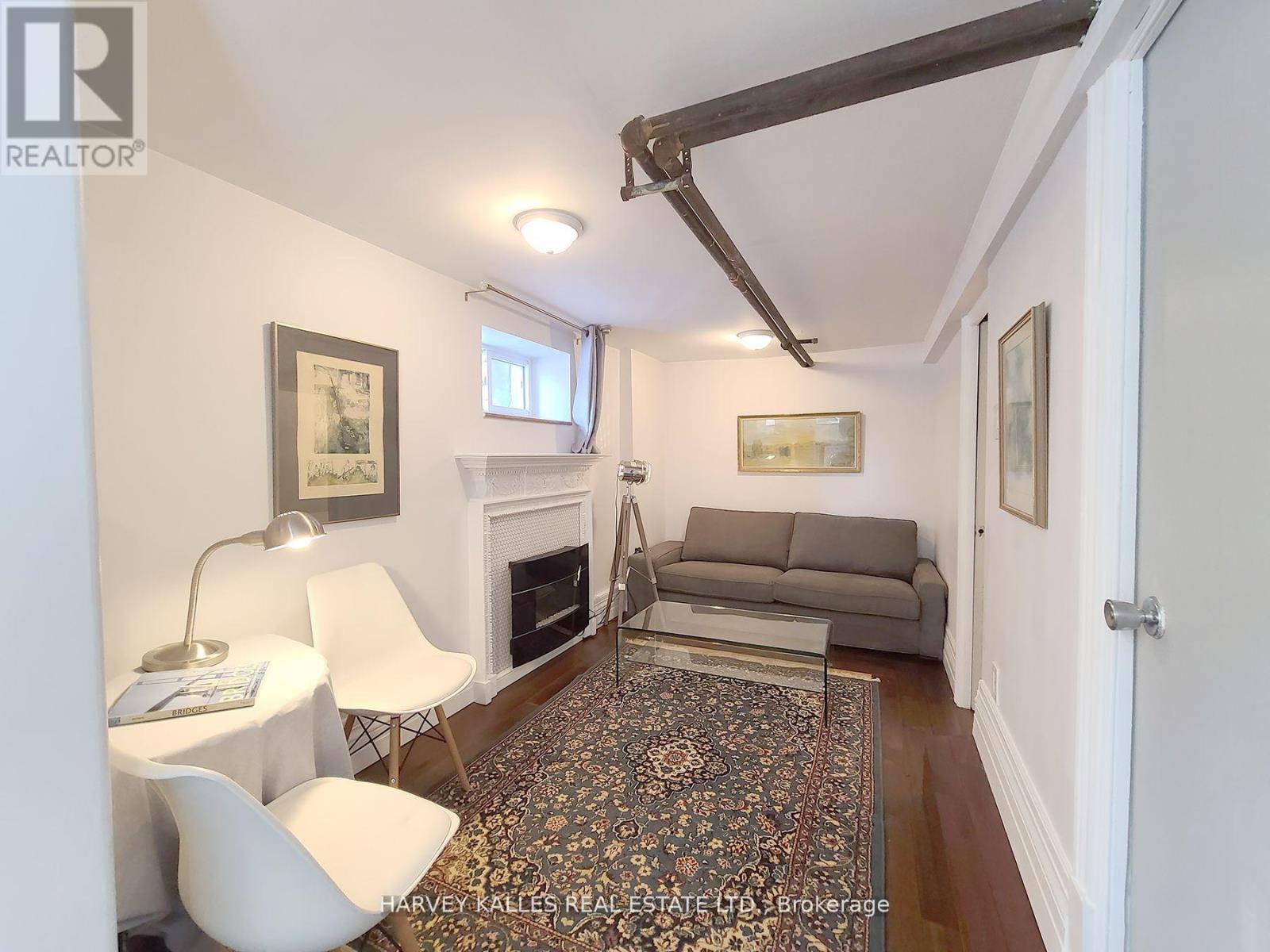 A living room with a fireplace and a rug on the floor.